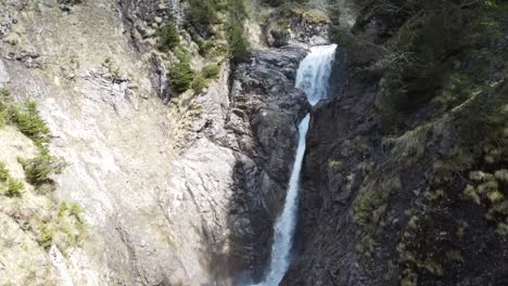 vista de un dron de una cascada entre las rocas en los alpes suizos