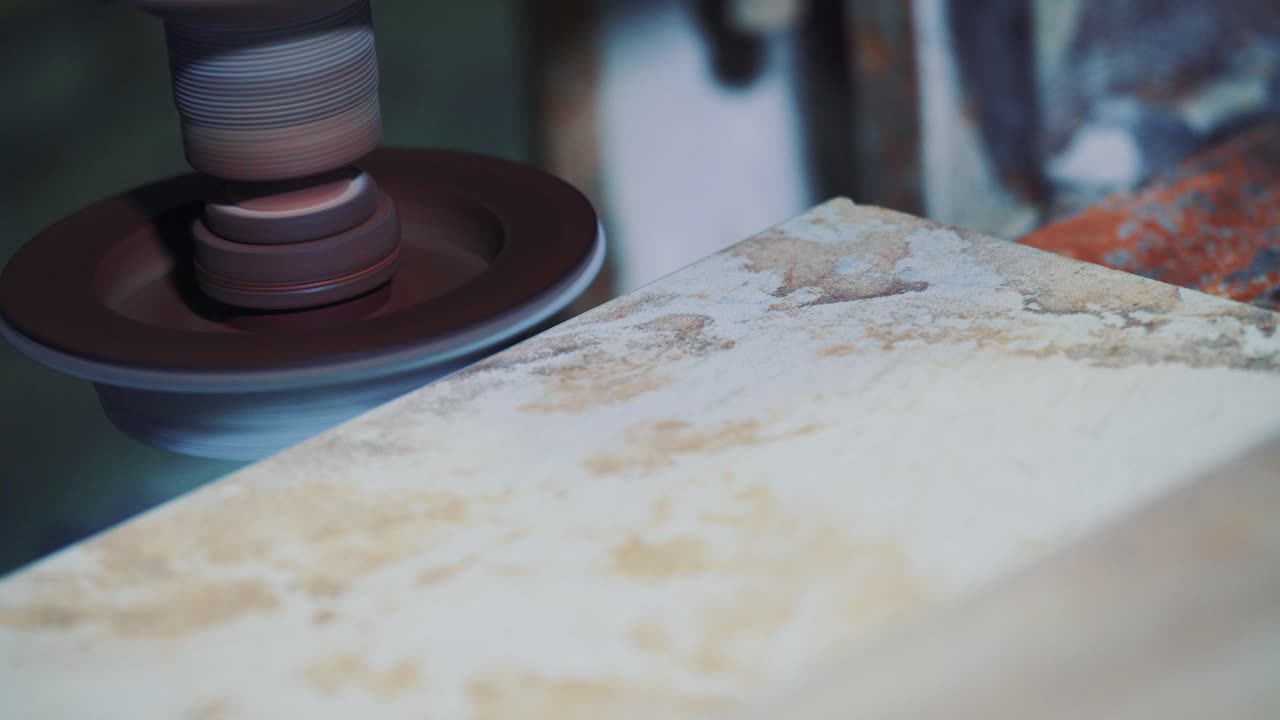 Sandstone processing on a polishing machine. Rounding a corner of a stone slab in a factory