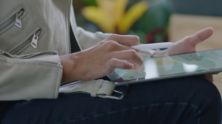 donne d'affari che utilizzano un tablet computer, sfogliano documenti di progetti aziendali su dispositivi touchscreen mobili, fanno brainstorming di idee creative per avviare con successo un'azienda, leggono informazioni da vicino