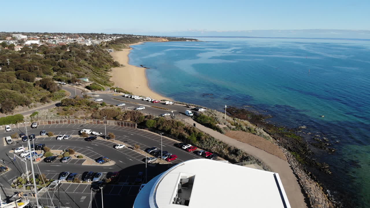 드론 비행으로 멜버른에 있는 샌드링엄의 스카이라인과 해안선을 보여줍니다.