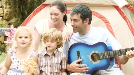 familia con una guitarra en un jardín