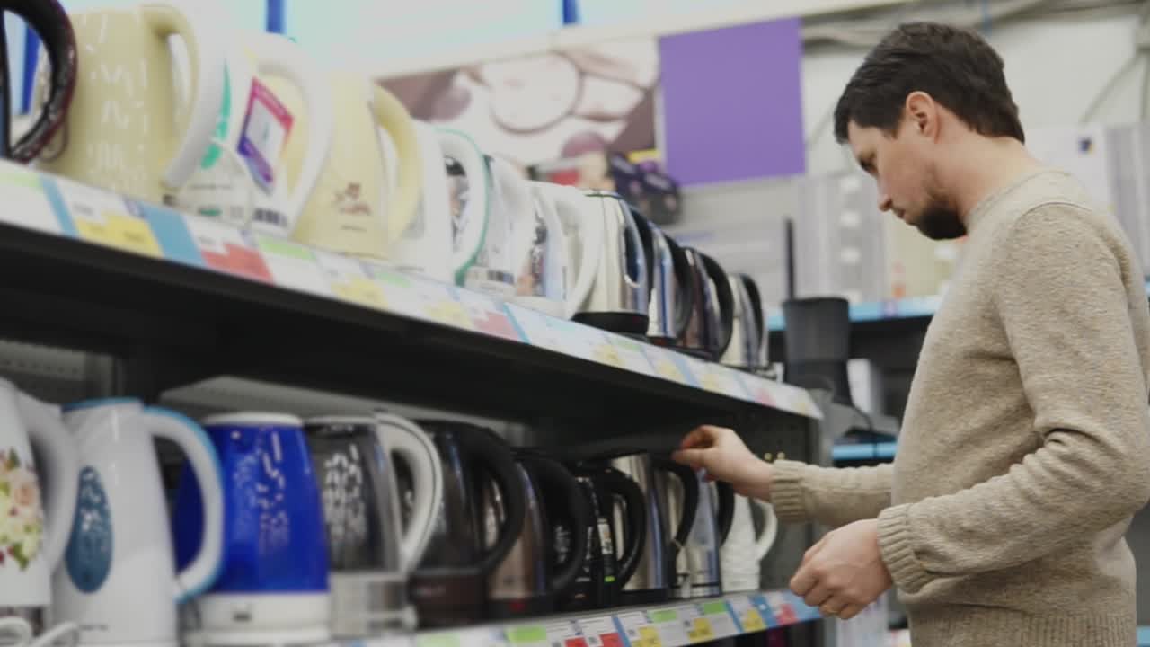 Man looking at electric kettles in a store
