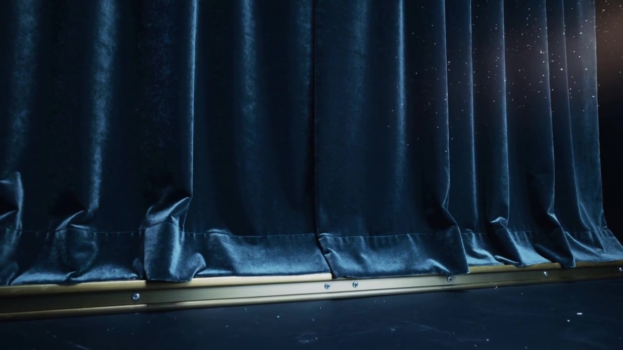 Shifting navy velvet curtain sliding on metal rail stage as offstage light appearing, stirring dust