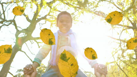 animation of orange autumn leaves falling over happy african american man and his son in park