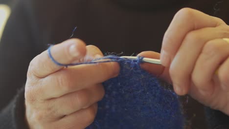 close up of the hands of an elderly woman knitting