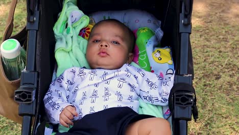 cute baby boy playing at stroller seat from flat angle