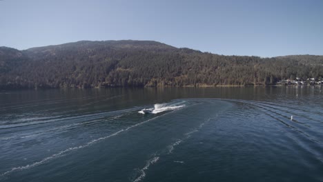 Drone-4K-Footage-of-recreational-speedboats-having-leisure-pastime-during-a-sunny-day-in-a-clam-lake-surrounded-by-mountains-cultus-bc-provincial-park