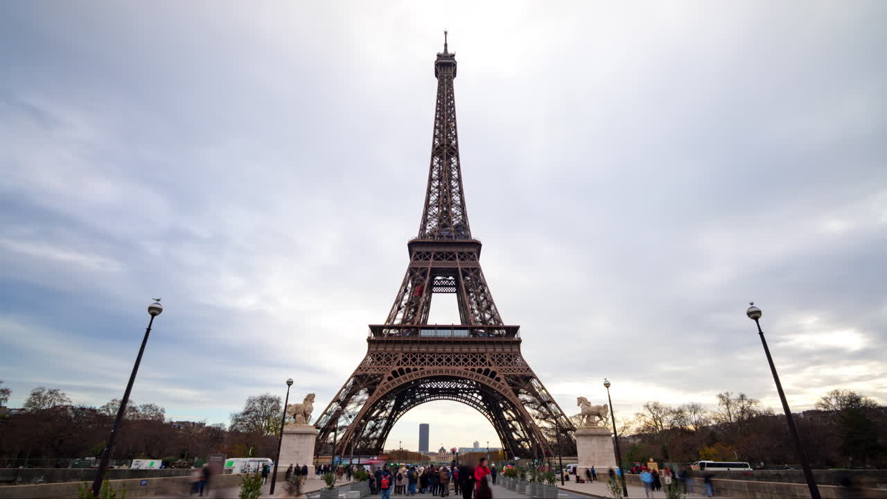 Hyperlapse con avvicinamento della Torre Eiffel a Parigi con turisti e traffico in una giornata nuvolosa
