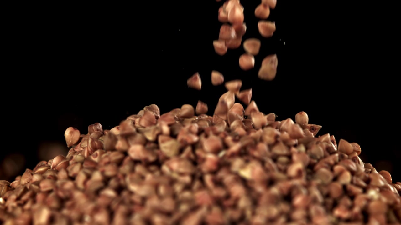 Chicchi di grano saraceno che cadono su un mucchio al rallentatore