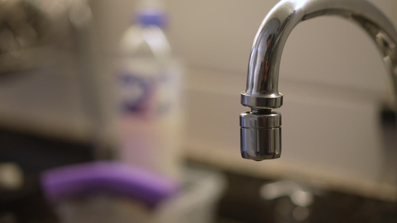 primer plano del grifo de la cocina con fugas en cámara lenta