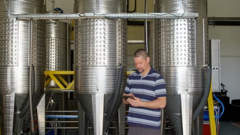 male worker using digital tablet in distillery 4k