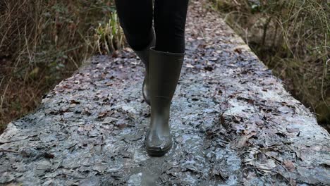 caminando en el barro de azufre con botas verdes antes de entrar a la antigua mina, primer plano