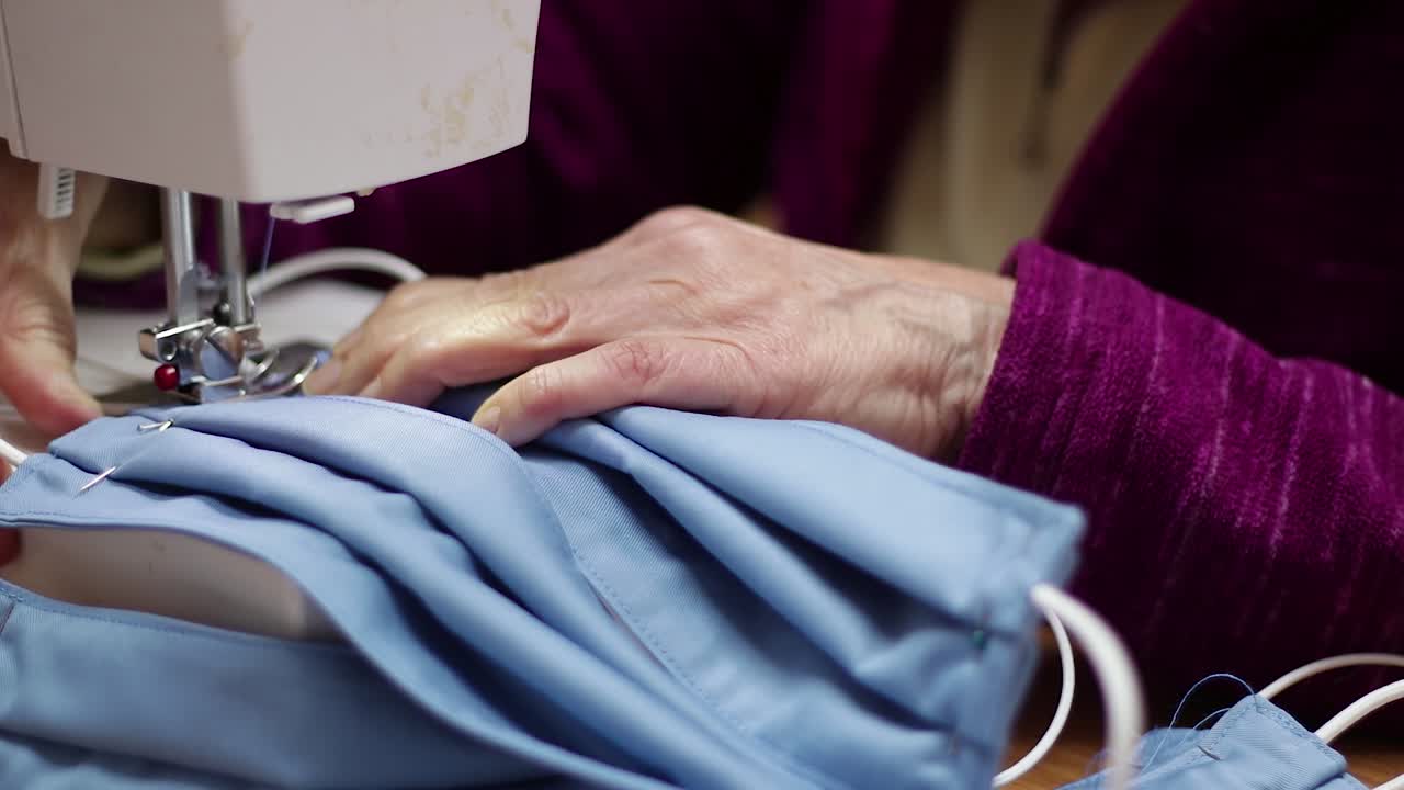 Seamstress finalizes homemade protective surgical mask against covid-19 coronavirus protective gear production