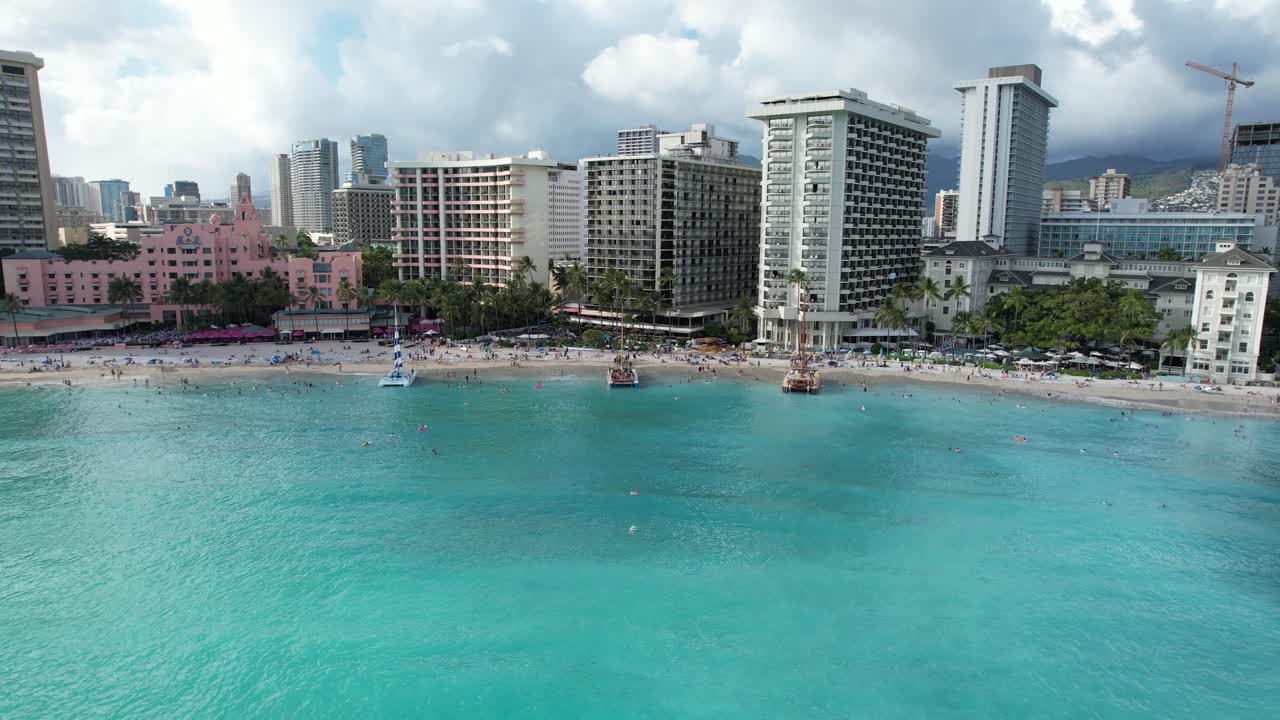 무인 항공기는 물 위의 바다에서 시작하여 해안가 고급 호텔을 향해 활공합니다.