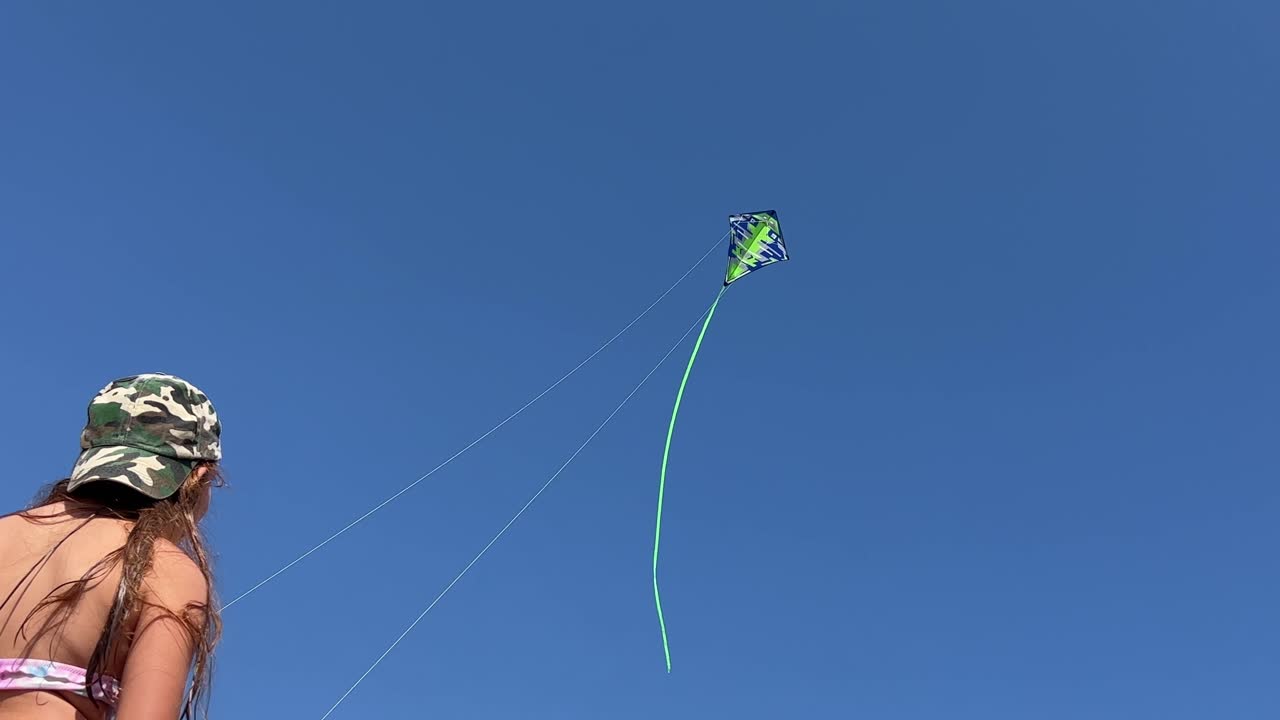 вид сзади под низким углом на стоящую маленькую рыжую девочку