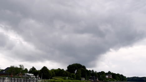dark clouds loom over a coastal town on the north sea, threatening to unleash nature's fury on the tranquil landscape gathering storm