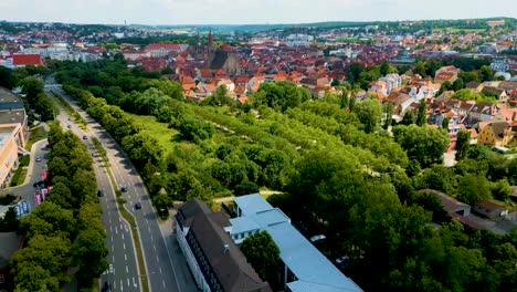 4k aerial drone video of the st. johannis kirche church along the frankische rezat river in downtown ansbach, germany