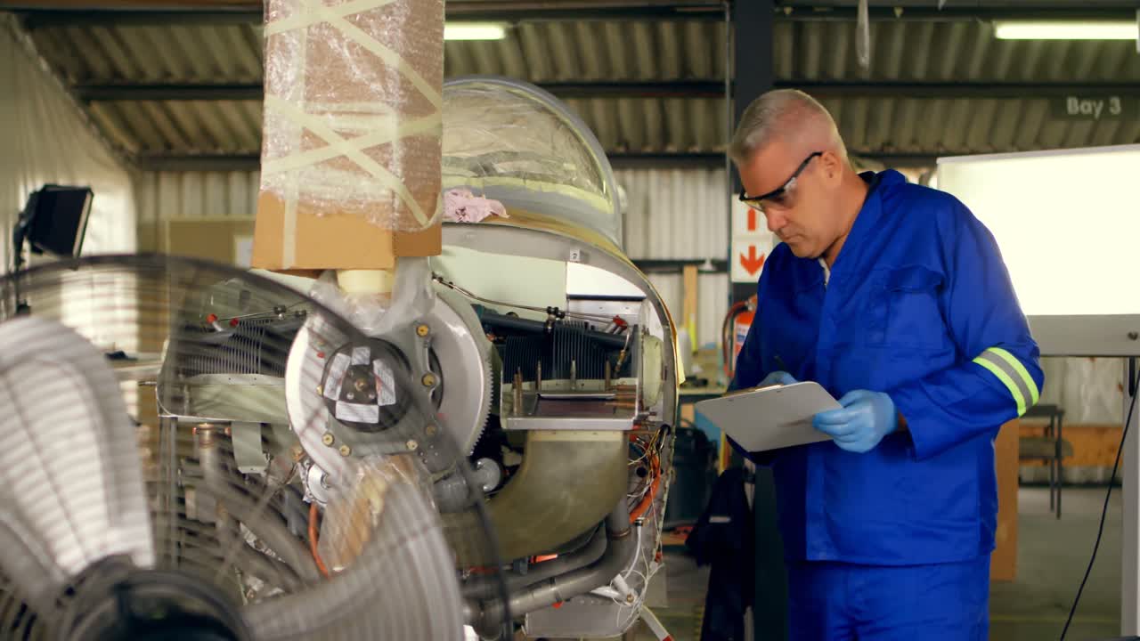 ingeniero comprobando una aeronave en el hangar 4k