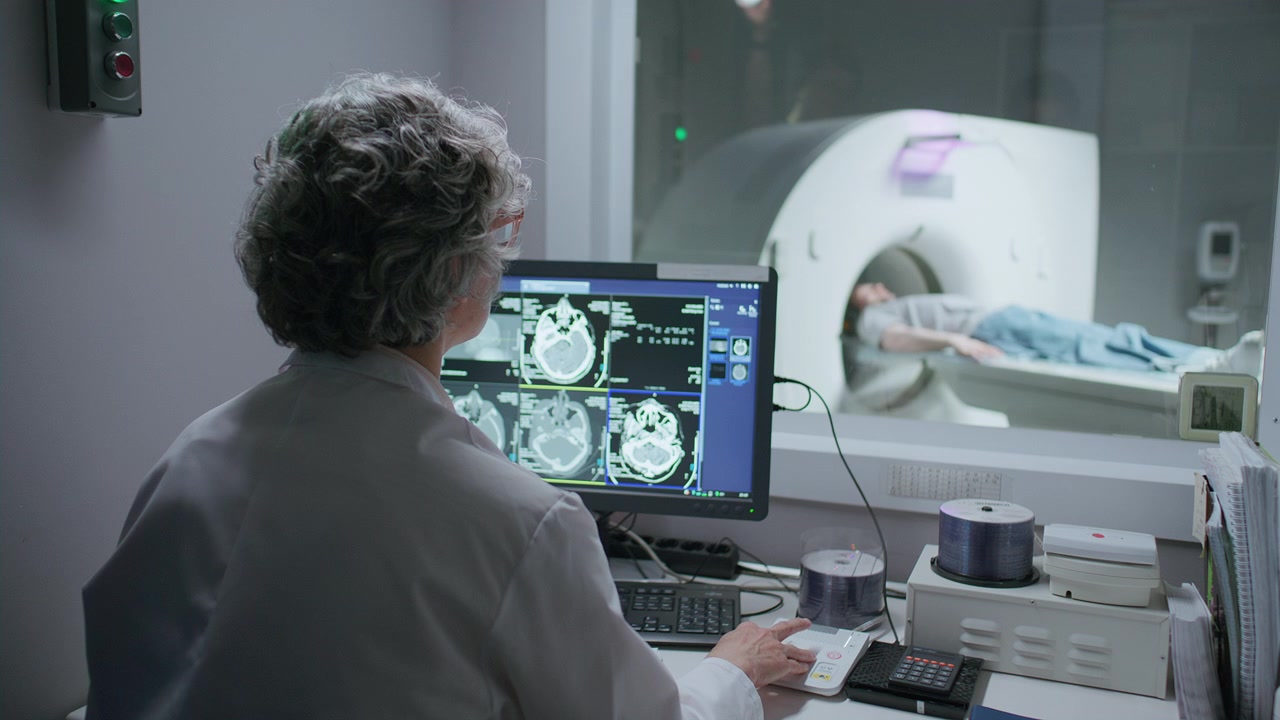 Radiologa che monitora un esame TC nella sala di controllo