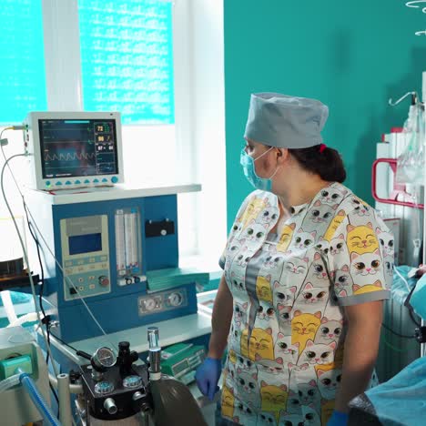 medical assistant near surgical equipment. nurse controls the heartbeat of a patient on the screen of monitor during surgery in modern hospital.