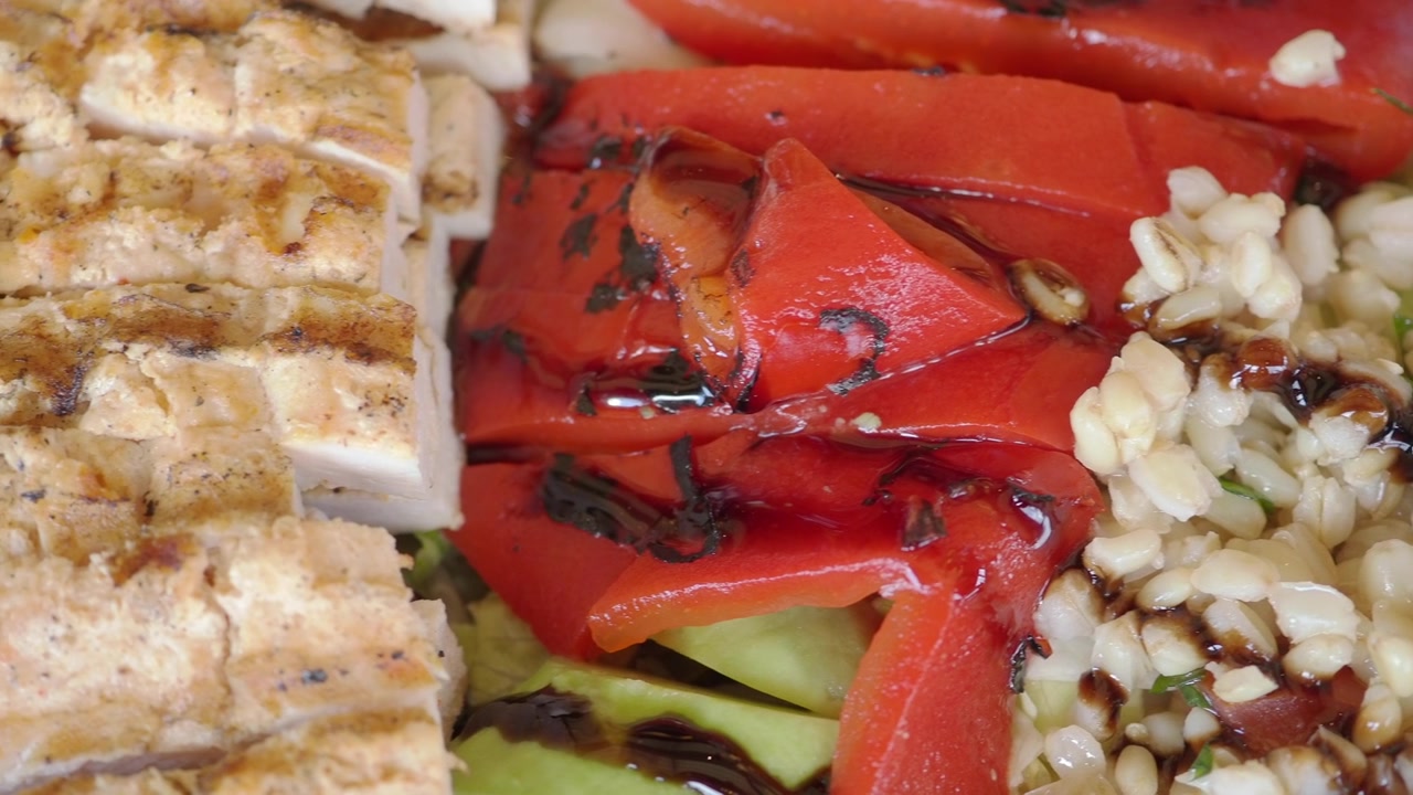 Primer plano de pollo a la parrilla, pimientos rojos y ensalada de cereales