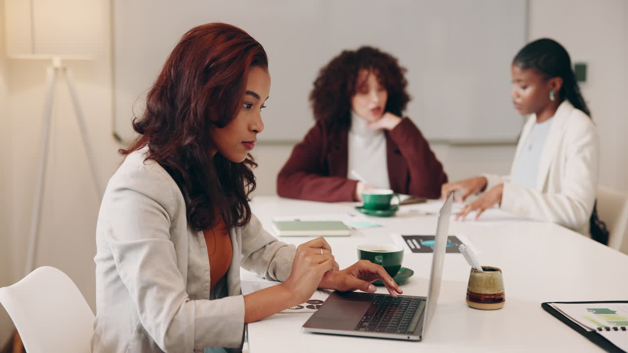 Three women having a meeting at a table in an office.