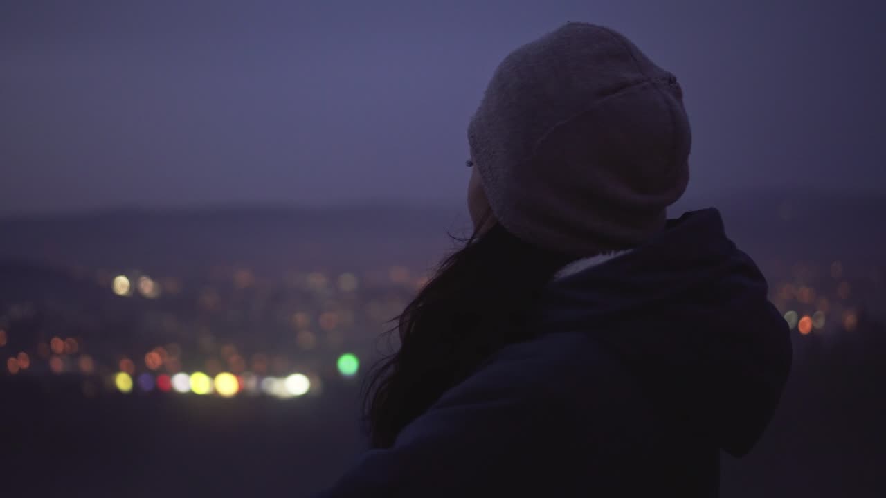 Ragazza che pensa a una rottura, vista laterale centrale, triste e malinconica, luci sfocate della città sullo sfondo