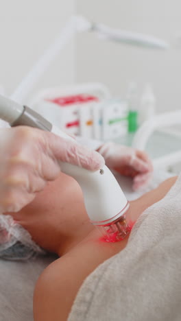 beautician makes woman rf lifting cosmetology procedure of face and eyes area collagen mask at spa