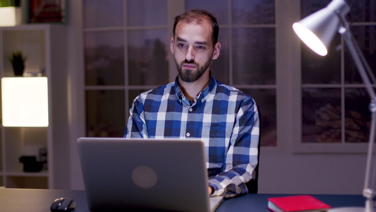 hombre trabajando en la computadora portátil por la noche