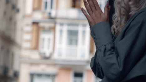 female hands touching urban background in city road at daytime.
