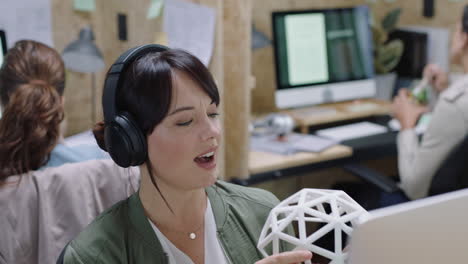 happy business woman talking using video chat showing geodesic dome design model brainstorming creative engineering ideas wearing headphones in office