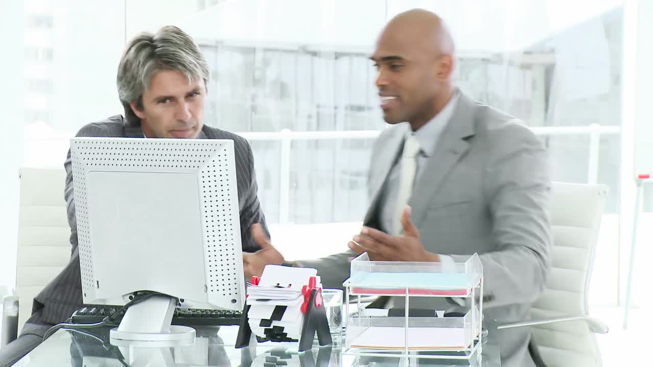 Two upset businessmen working at a computer