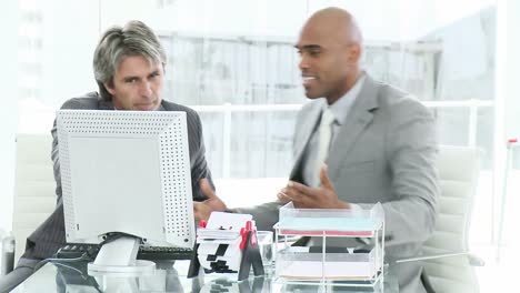 dos hombres de negocios molestos trabajando en una computadora