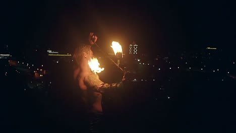 un joven hombre rubio exhala una gran corriente de fuego haciendo una bola de fuego en cámara lenta