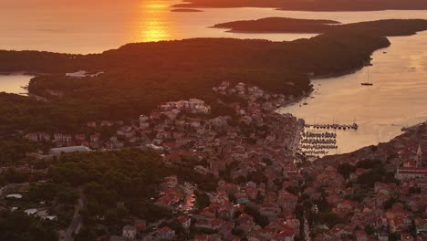 Watch the sun dip below the horizon over Mali Lošinj, with this stunning aerial view. The warm hues of sunset reflect over the crystal-clear waters, creating a serene and breathtaking coastal scene.
