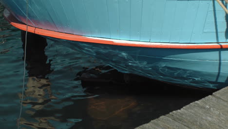 Agua-Que-Refleja-El-Sol-En-La-Parte-Trasera-De-Un-Antiguo-Barco-De-Vela-Holandés-Histórico-De-Madera-Tendido-En-El-Puerto