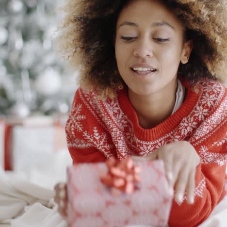 Thoughtful-young-woman-with-a-Christmas-gift
