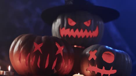 video of halloween carved pumpkins and smoke with copy space on blue background