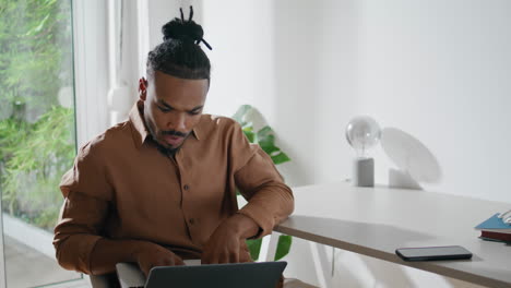 Involved-student-watching-laptop-workplace.-Focused-man-looking-screen-at-home