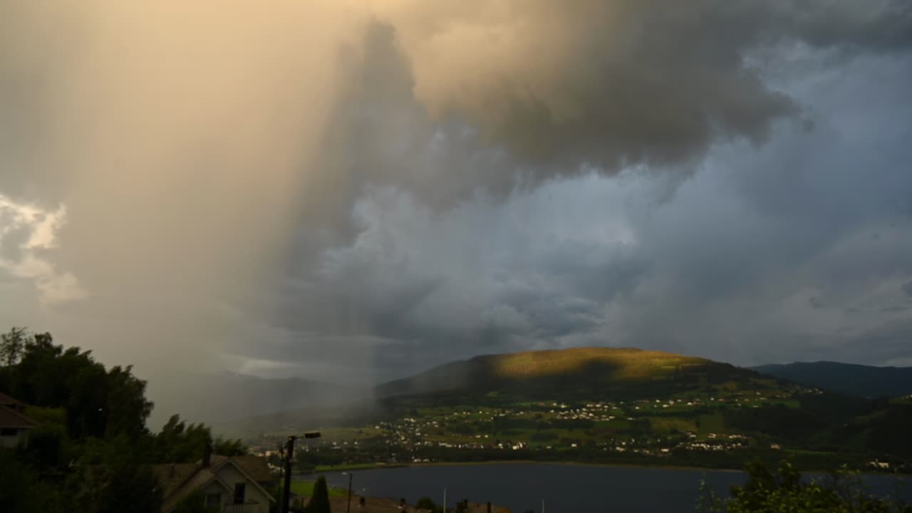 Huge lightning strike erupts from storm clouds above Voss and Vangsvatnet lake during summer storm