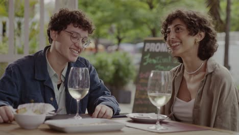Two people enjoying a meal and drinks at an outdoor restaurant