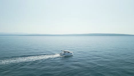 a boat cruising on calm blue water under a clear sky