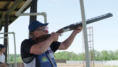 sportsman shoots from a double-barreled shotgun, a sports field for a shooting test is shooting at flying skeet