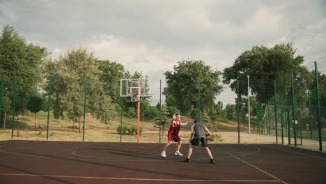 Dos-Deportistas-Jugando-Baloncesto-En-Una-Cancha-Al-Aire-Libre