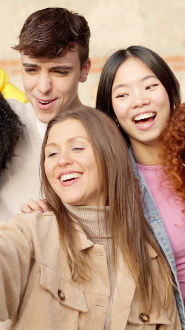 Multi-ethnic young friends celebrating while taking a selfie outdoors