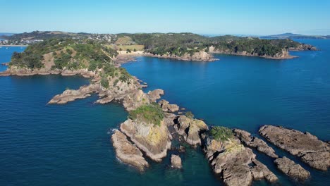 Afloramientos-Escarpados-En-La-Bahía-De-Oneroa-Con-Tranquilas-Aguas-Azules-En-Auckland,-Nueva-Zelanda