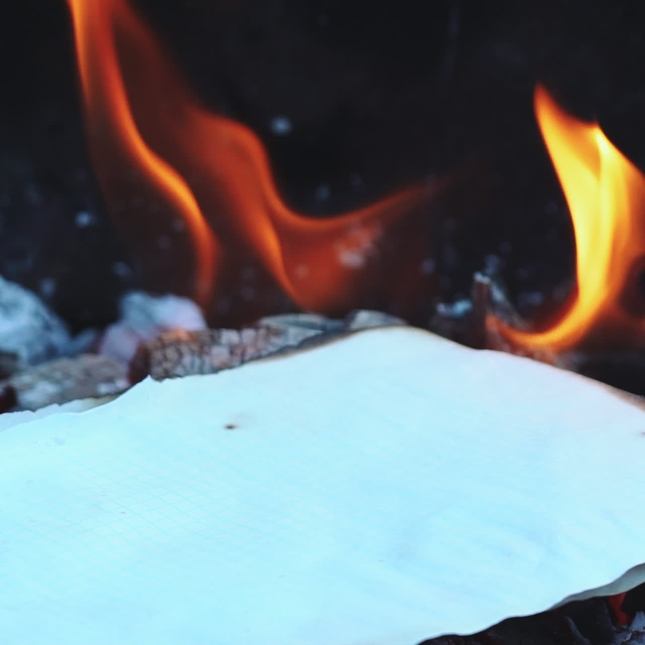 Paper burning in the bonfire flame. Camp fire in the night. Slow motion