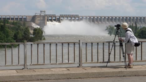 Fotograf-Mit-Stativ-Fotografiert-Staudamm,-Der-Wasser-Freisetzt