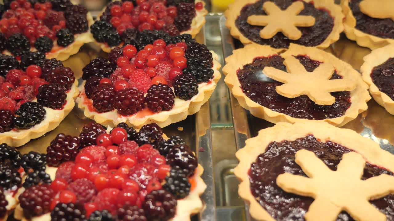 Deliziose tartellette alla frutta e alla marmellata in esposizione in una pasticceria