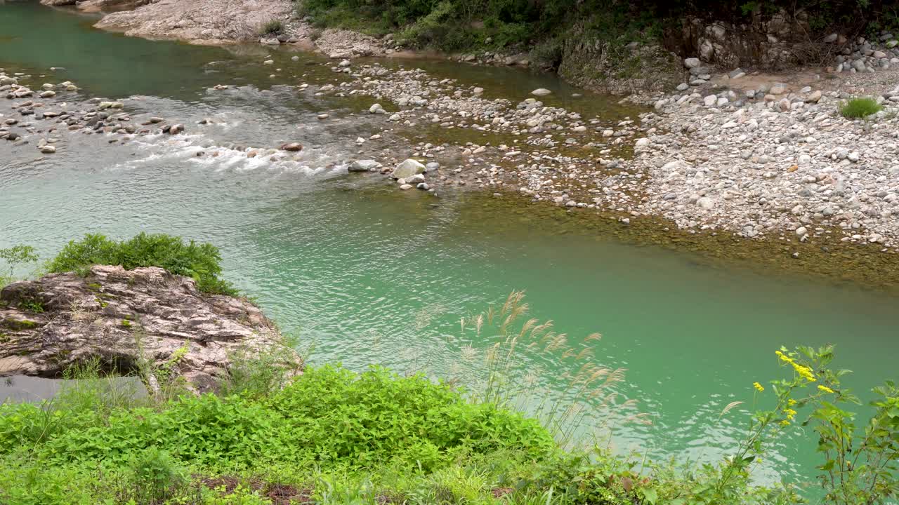 산의 신선한 물이 바위 강으로 흘러들어간다.